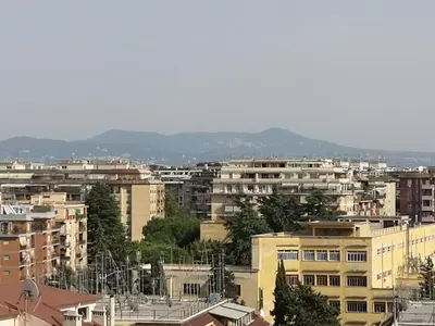 a city with buildings and mountains in the background at Checchi House in Rome