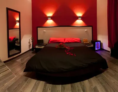 a bedroom with a large bed with red walls at Chroma Exy - Chroma Italy in Rome