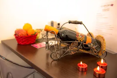 a bottle of wine on a table with candles at Chroma Exy - Chroma Italy in Rome