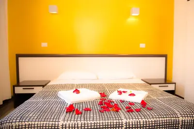 a bed with two white towels and red roses on it at Chroma Exy - Chroma Italy in Rome