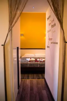 a room with a bed with a yellow wall at Chroma Exy - Chroma Italy in Rome