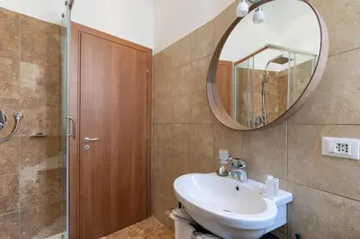 a bathroom with a sink and a mirror and a shower at Vatican Domus Smart Rooms in Rome