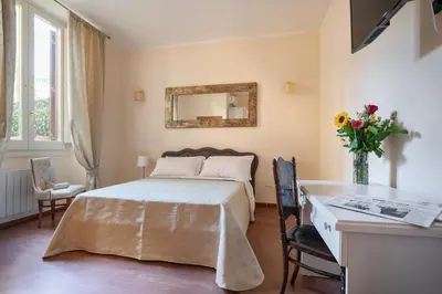 a bedroom with a bed and a desk and a mirror at Vatican Domus Smart Rooms in Rome