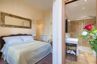 a bedroom with a bed and a sink and a mirror at Vatican Domus Smart Rooms in Rome