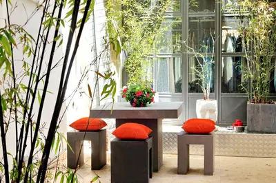 a bench with two red pillows sitting in a courtyard at Design Loft Campo dei Fiori in Rome
