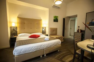 a hotel room with a large bed and a table at Aventino Guest House in Rome