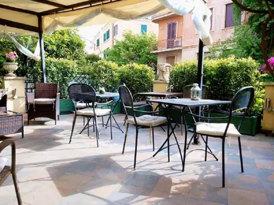 a patio with tables and chairs under an umbrella at Aventino Guest House in Rome