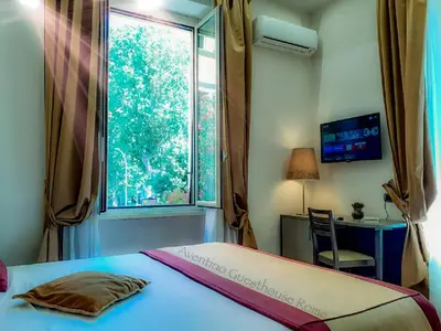 a bedroom with a bed and a window and a desk at Aventino Guest House in Rome