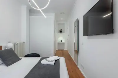 a bedroom with a bed with a flat screen tv on the wall at 500 Suite Prati delle Vittorie in Rome
