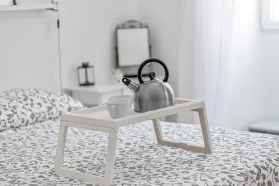 a tea kettle on a table on a bed at La casa di Effe in Rome