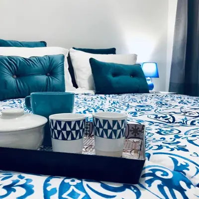 a bed with blue and white sheets and blue pillows at Mamma Roma 151 in Rome