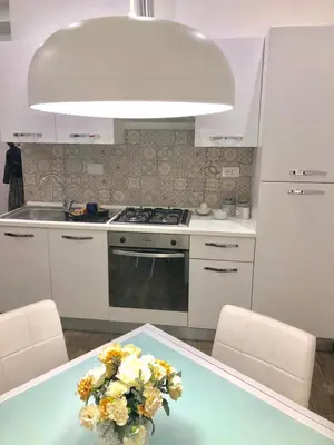 a kitchen with a table with a vase of flowers on it at Mamma Roma 151 in Rome