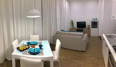 a living room with a white table and a couch at Mamma Roma 151 in Rome