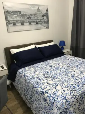 a bedroom with a bed with a blue and white comforter at Mamma Roma 151 in Rome