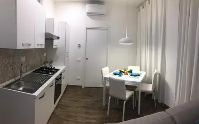 a kitchen with a table with chairs and a sink at Mamma Roma 151 in Rome