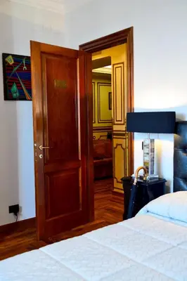 a bedroom with a bed and a wooden door at Regal House Roma Navigatori 23 in Rome