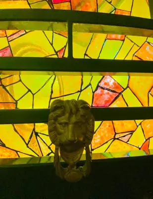 a statue of a face in front of a stained glass window at Ancient Roman Mansion in Rome