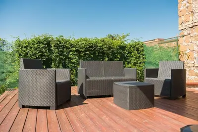 four wicker chairs and a table on a deck at Casa Vacanze Casilina in Rome