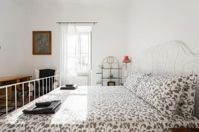a bedroom with a white bed with a black and white comforter at Casa Vacanze Casilina in Rome