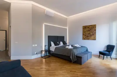 a bedroom with a bed and a blue chair at President Gardens in Rome