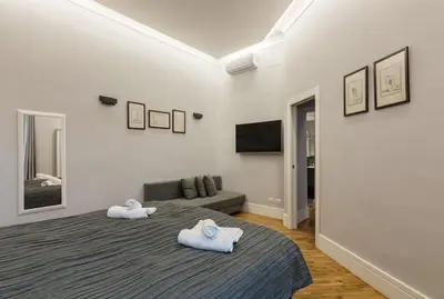 a bedroom with two towels on a bed with a couch at President Gardens in Rome