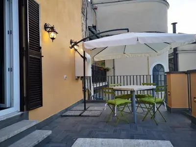 a table and chairs with an umbrella on a balcony at President Gardens in Rome