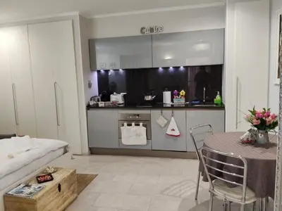 a living room with a table and a kitchen at La Calla al Colosseo in Rome