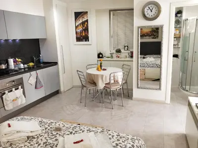 a kitchen and dining room with a table and chairs at La Calla al Colosseo in Rome
