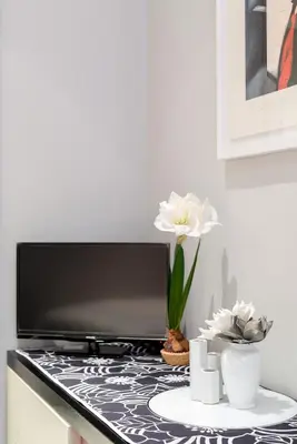 a kitchen counter with a table with flowers on it at Rome in your heart - Spagna Single Room in Rome
