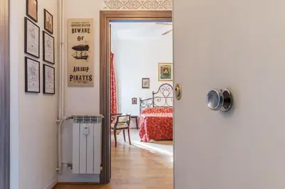 a hallway with a door open to a room with a bed at San Paolo Steampunk Flat in Rome