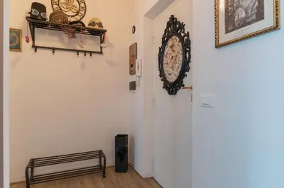 a hallway with a door and a clock on the wall at San Paolo Steampunk Flat in Rome