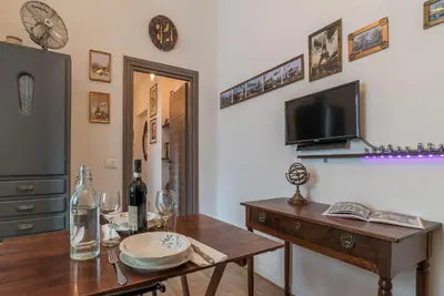 a dining room with a wooden table and a tv at San Paolo Steampunk Flat in Rome