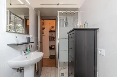 a white bathroom with a sink and a mirror at San Paolo Steampunk Flat in Rome