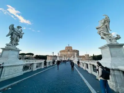 people walking across a bridge in front of a building at Vatican Home in Rome - Suite St. Peter's View in Rome