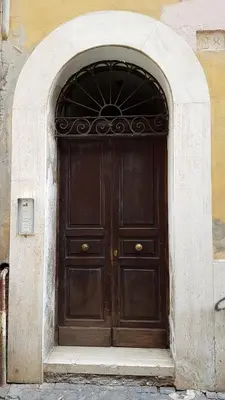a large wooden door in an arch way at Vatican Home in Rome - Suite St. Peter's View in Rome
