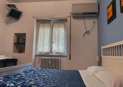 a bedroom with a bed and a window at Ale&Andrea Apartments BLU & LILLA in Rome