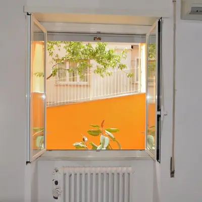 a window with an orange wall and some plants at Ale&Andrea Apartments BLU & LILLA in Rome