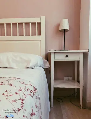 a bedroom with a bed and a table with a lamp at Ale&Andrea Apartments BLU & LILLA in Rome