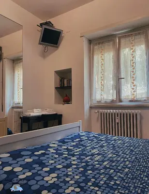 a bedroom with a bed and a tv on the wall at Ale&Andrea Apartments BLU & LILLA in Rome