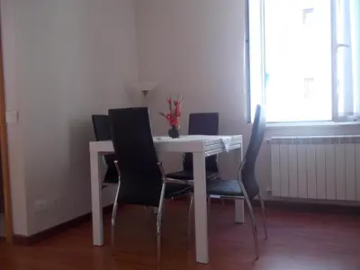 a dining room table with black chairs and a white table at L'attico di Val. in Rome