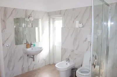 a white bathroom with a toilet and a sink at Santa Maria Suites in Rome
