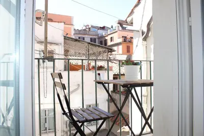 a table and a chair sitting on a balcony at Santa Maria Suites in Rome