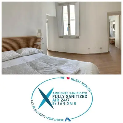 a white bedroom with a bed and a mirror at Santa Maria Suites in Rome
