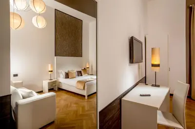 two pictures of a room with a bed and a living room at Domus Liberius - Rome in Rome