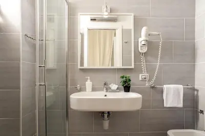 a bathroom with a sink and a shower and a mirror at Domus Liberius - Rome in Rome