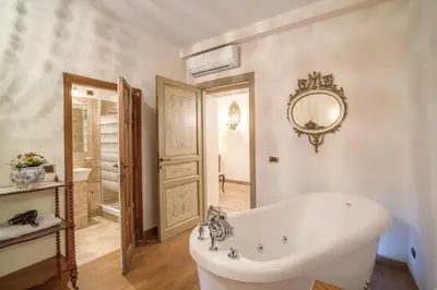 a white bathroom with a tub and a mirror at Navona Gallery Suites in Rome