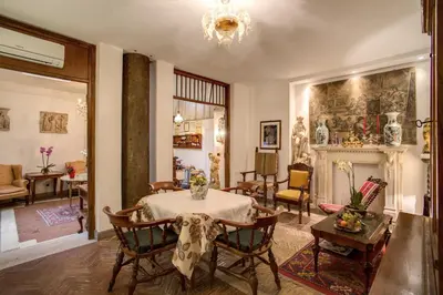 a living room with a table and chairs and a fireplace at Navona Gallery Suites in Rome