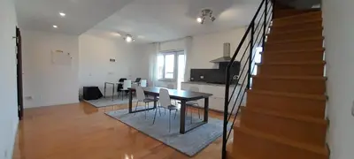 a living room with a dining room table and stairs at Guesthouse Vassallo Due in Rome