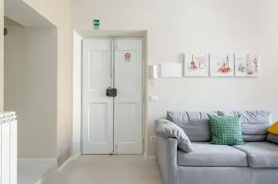 a living room with a gray couch and a door at SuityRHome RioneMonti54 in Rome