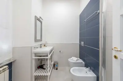 a white bathroom with a sink and a toilet at SuityRHome RioneMonti54 in Rome